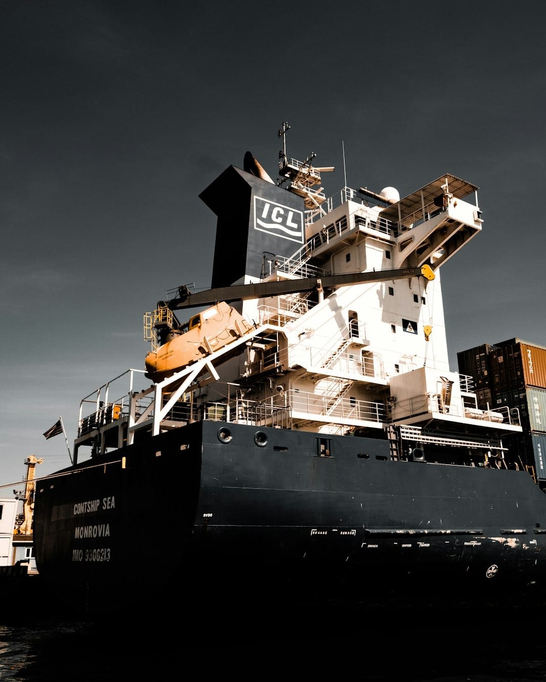Large dark blue cargo ship with 'CONTSHIP SEA' on stern.